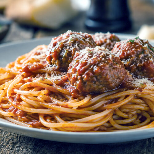 Spaghetti og kødboller i tomatsauce og revet Parmesanost.